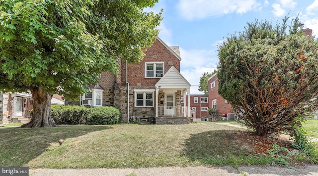 view of front of house featuring a front yard, brick siding, and stone siding