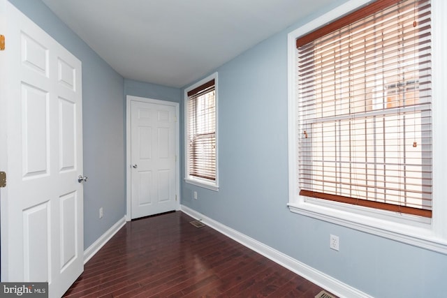 interior space featuring visible vents, dark wood finished floors, and baseboards