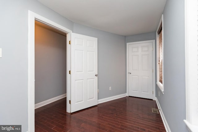 unfurnished bedroom with visible vents, baseboards, and wood finished floors