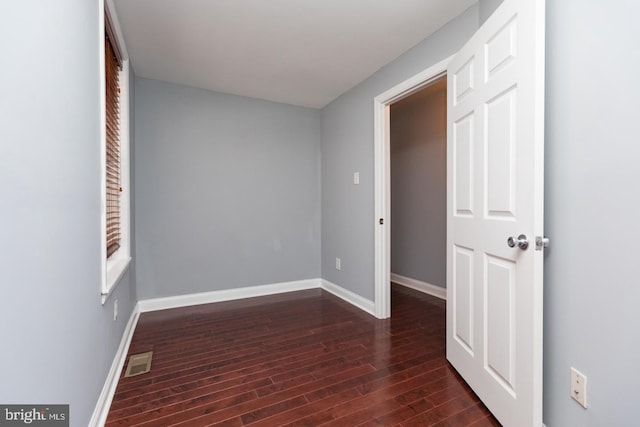 interior space featuring baseboards, visible vents, and dark wood-type flooring