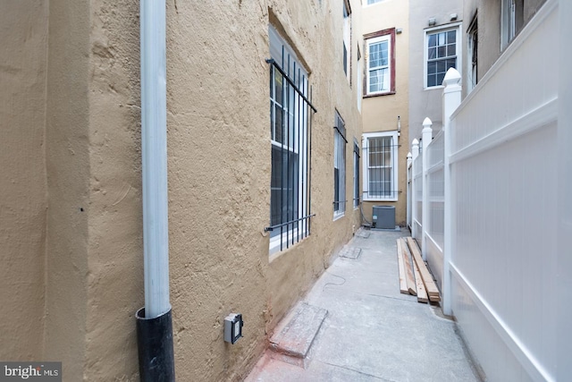 view of property exterior featuring a patio area, cooling unit, and stucco siding