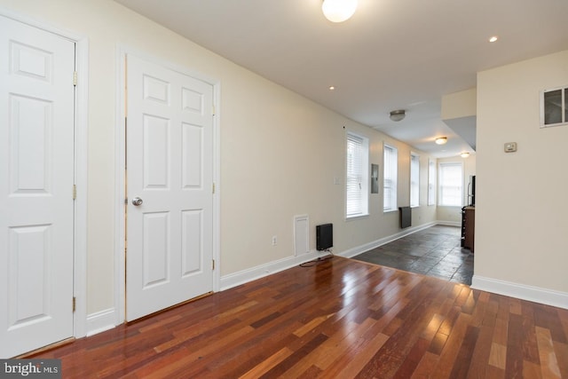 spare room featuring wood-type flooring and baseboards