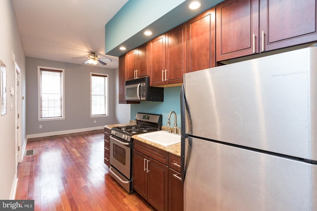 kitchen with visible vents, ceiling fan, appliances with stainless steel finishes, wood finished floors, and a sink