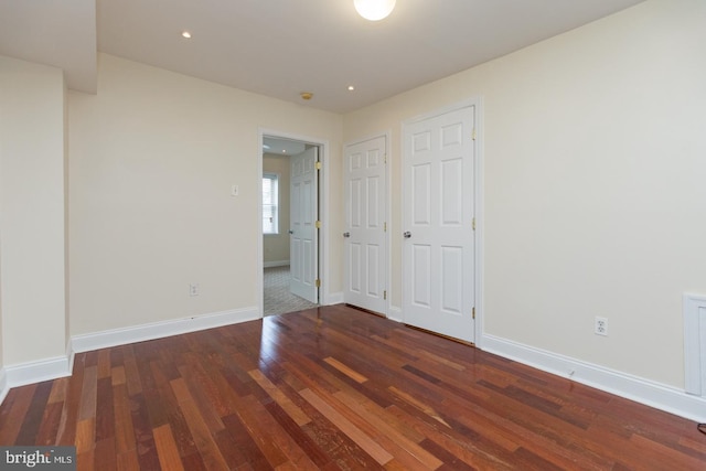 spare room with baseboards, wood finished floors, and recessed lighting