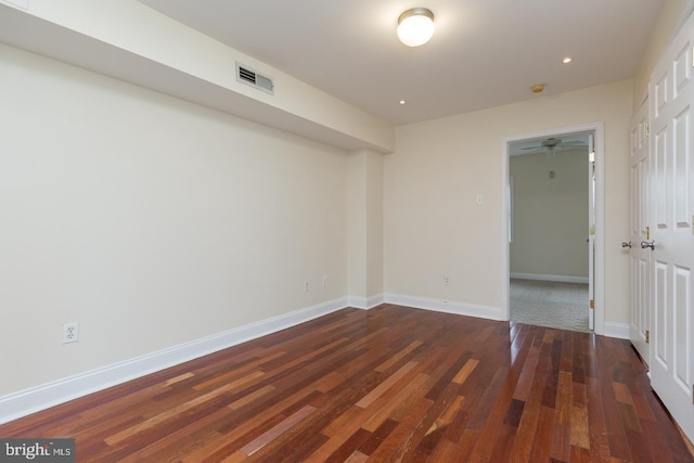 spare room featuring recessed lighting, visible vents, dark wood finished floors, and baseboards