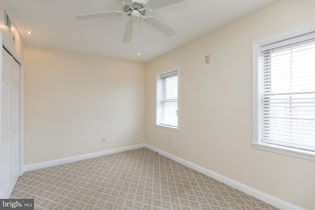 unfurnished bedroom with recessed lighting, a closet, light colored carpet, visible vents, and baseboards