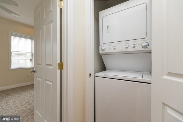 clothes washing area featuring stacked washer and clothes dryer, carpet flooring, baseboards, and laundry area