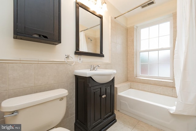 full bathroom featuring toilet, vanity, visible vents, tile walls, and tile patterned floors