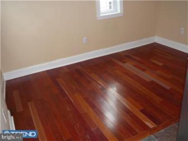 unfurnished room featuring wood finished floors and baseboards