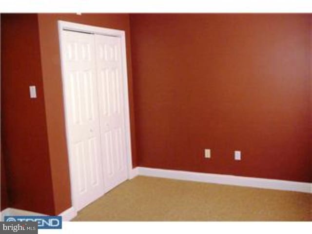 unfurnished bedroom featuring baseboards and a closet