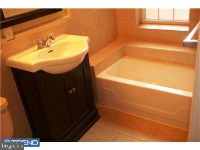 full bath with a bath, vanity, and tile patterned floors