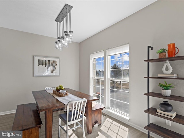 dining room featuring baseboards, a notable chandelier, and wood finished floors