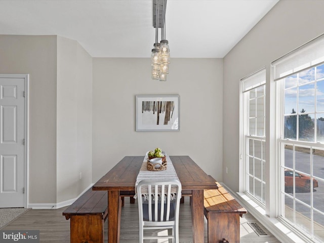 dining space featuring baseboards, wood finished floors, visible vents, and breakfast area