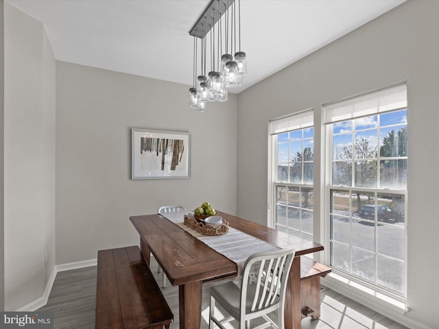 dining area with a notable chandelier, wood finished floors, and baseboards