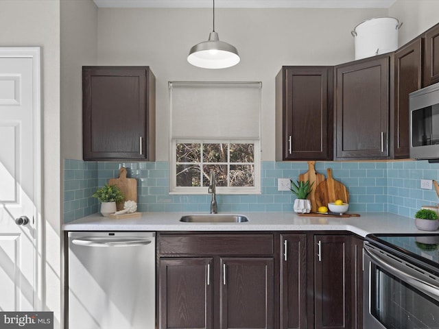 kitchen with a sink, dark brown cabinetry, light countertops, appliances with stainless steel finishes, and backsplash