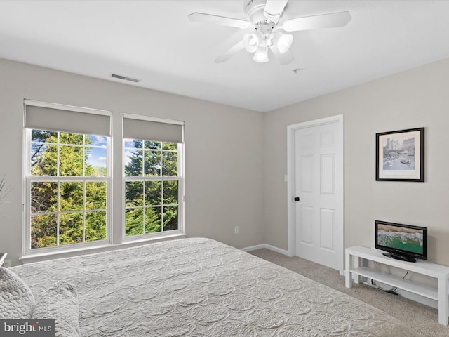 carpeted bedroom featuring visible vents, baseboards, and ceiling fan