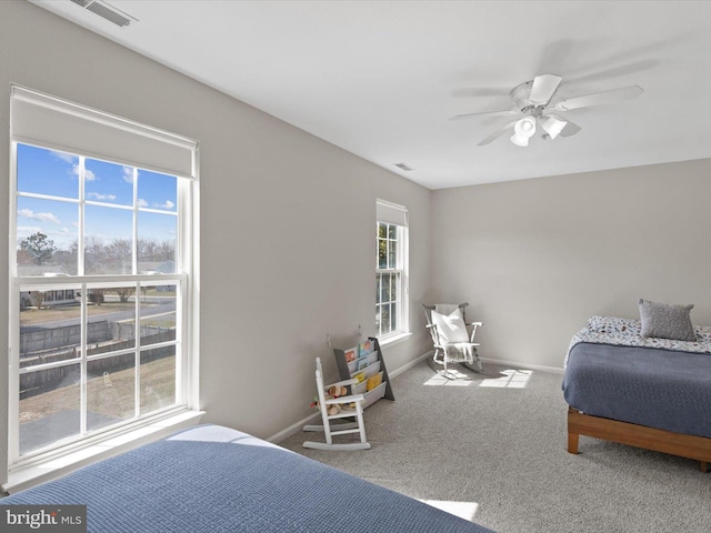 carpeted bedroom with visible vents, ceiling fan, and baseboards