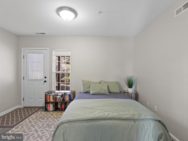 bedroom with visible vents, carpet flooring, and baseboards