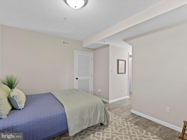 bedroom featuring visible vents, baseboards, and light wood-style floors