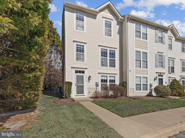 townhome / multi-family property with a front lawn and central AC