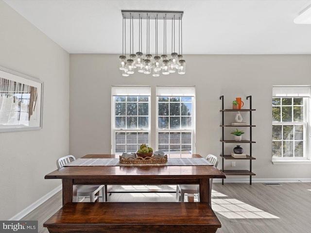 dining room with visible vents, wood finished floors, and baseboards