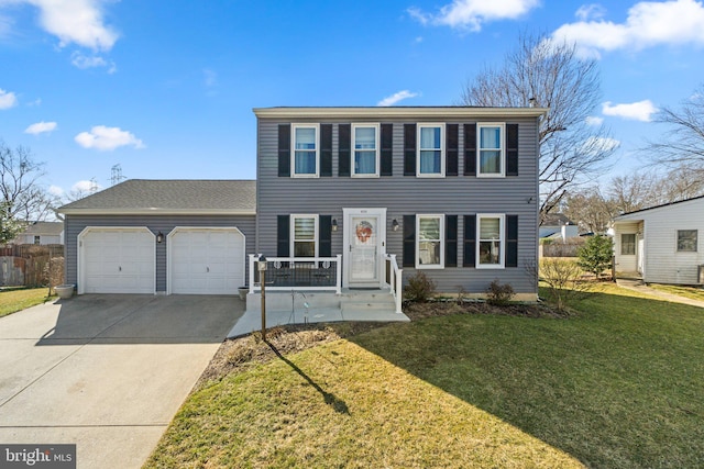 colonial home featuring a front lawn, fence, a garage, and driveway