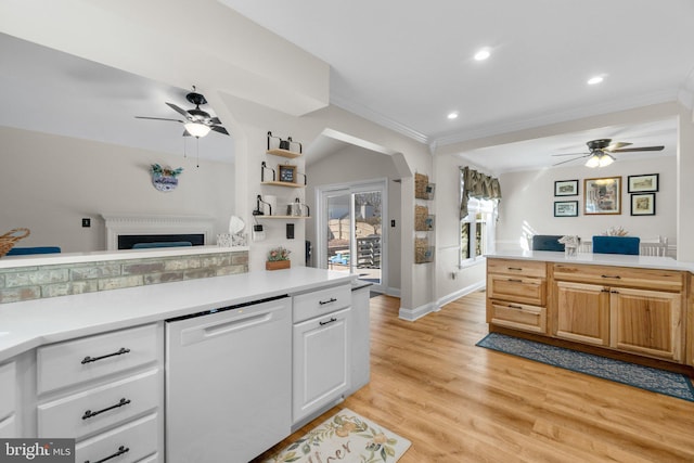 kitchen with light wood-style flooring, ornamental molding, arched walkways, light countertops, and dishwasher