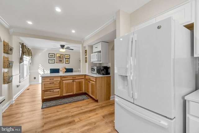 kitchen with light countertops, ornamental molding, a peninsula, light wood-style floors, and white appliances