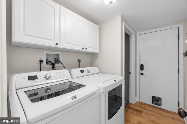 laundry room with washer and dryer, cabinet space, and light wood finished floors