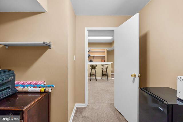 hallway featuring baseboards and carpet