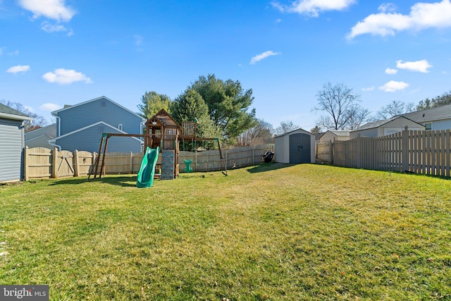 view of yard with a storage shed, a playground, a fenced backyard, and an outdoor structure