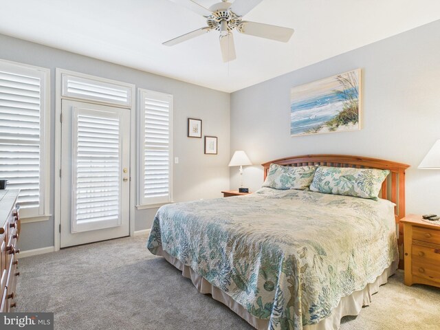 carpeted bedroom featuring ceiling fan, baseboards, and access to exterior