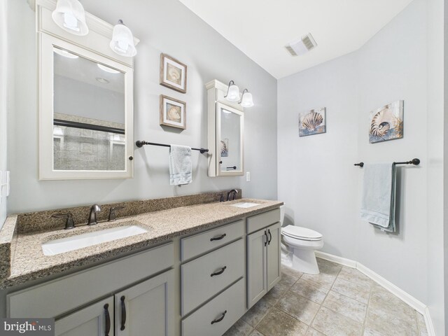 bathroom featuring toilet, baseboards, visible vents, and a sink