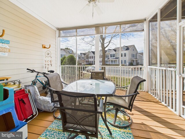 sunroom / solarium with a residential view, plenty of natural light, and ceiling fan