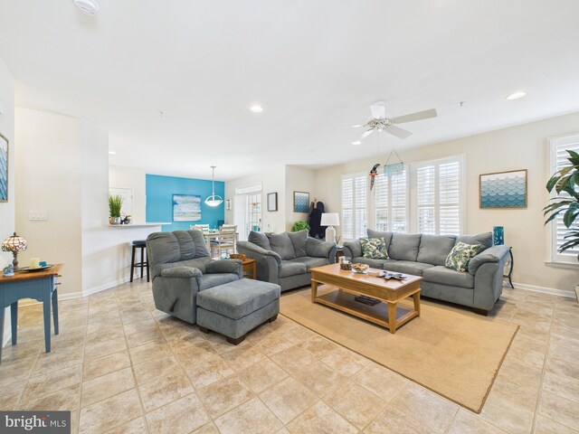 living area with a ceiling fan, recessed lighting, baseboards, and light tile patterned floors