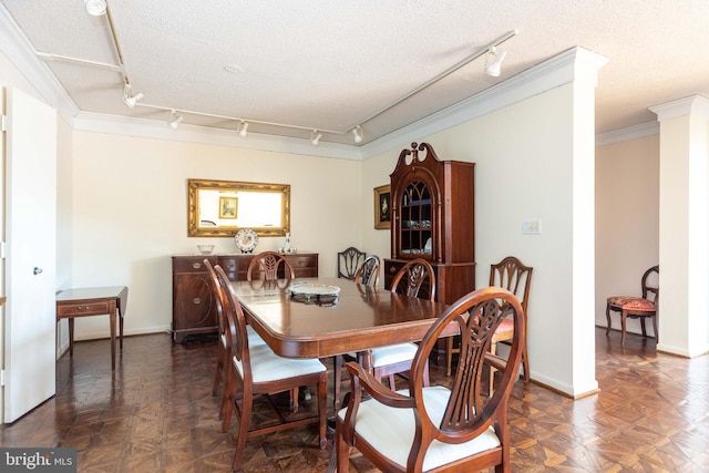 dining area featuring a textured ceiling, crown molding, and baseboards