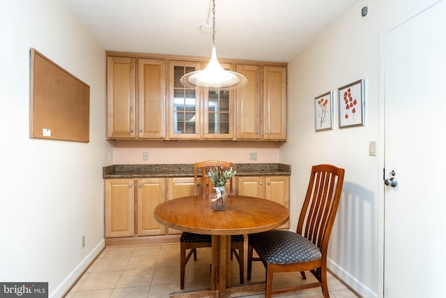 dining area with baseboards and light tile patterned flooring