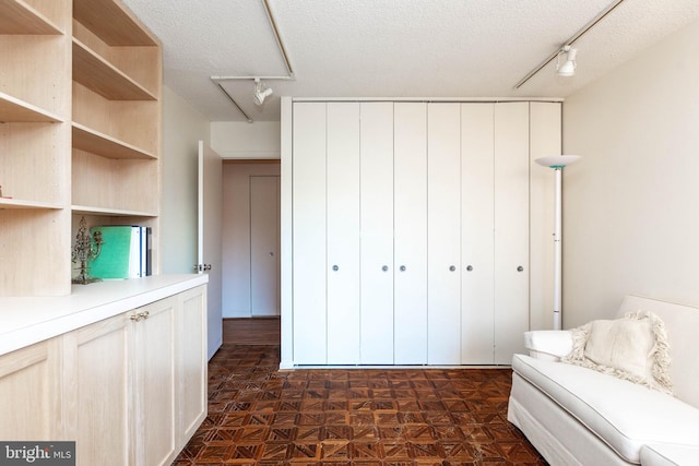 unfurnished room with rail lighting and a textured ceiling