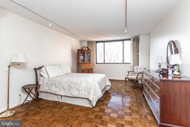 bedroom featuring a textured ceiling and rail lighting