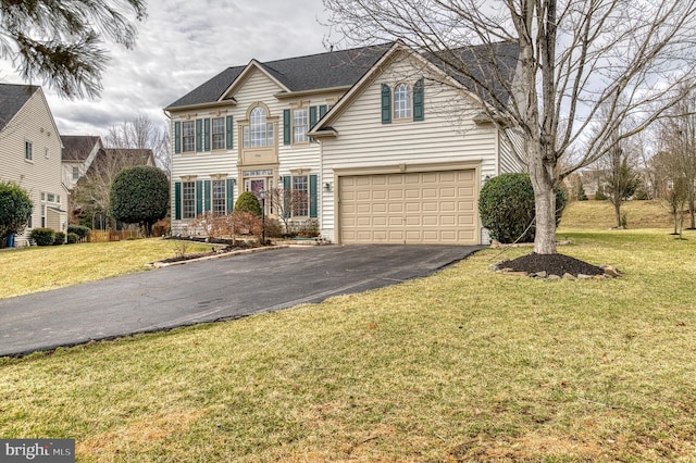 traditional-style home with a front yard, an attached garage, and driveway