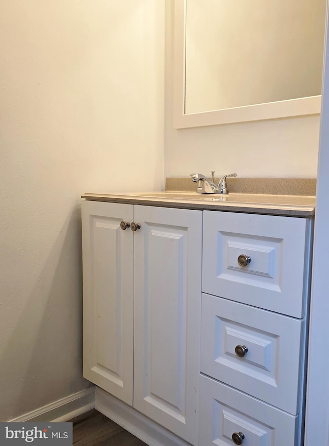 bathroom with vanity, baseboards, and wood finished floors