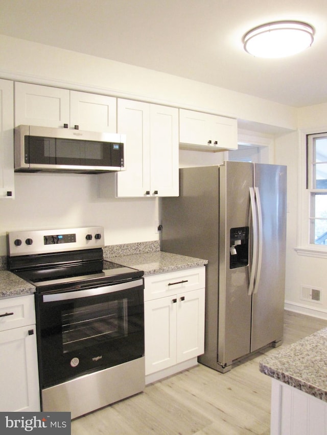 kitchen with light wood finished floors, visible vents, appliances with stainless steel finishes, and white cabinetry