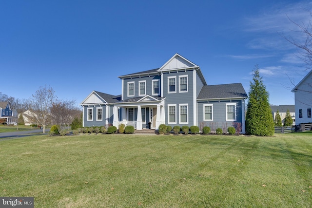 view of front of house with board and batten siding, a front yard, and stone siding