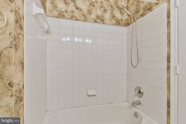 bathroom featuring bathtub / shower combination and wallpapered walls