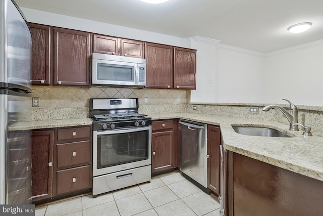 kitchen with crown molding, light tile patterned floors, backsplash, appliances with stainless steel finishes, and a sink