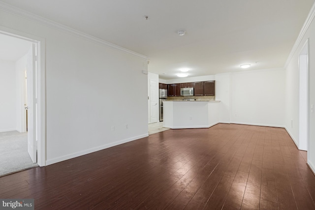 unfurnished living room featuring crown molding, dark wood finished floors, and baseboards