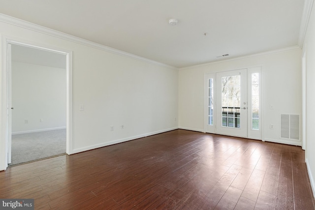 spare room featuring dark wood-style floors, baseboards, visible vents, and crown molding