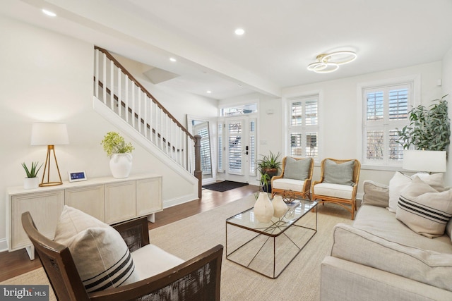 living area featuring stairs, wood finished floors, and a wealth of natural light