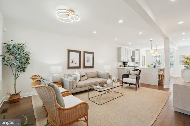 living area featuring visible vents, baseboards, wood finished floors, and recessed lighting