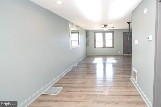 unfurnished room with baseboards, visible vents, and light wood-style flooring